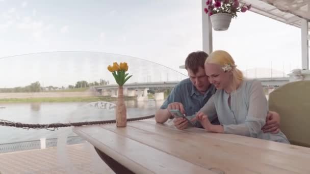 Belo casal assistindo fotos em um smartphone . — Vídeo de Stock