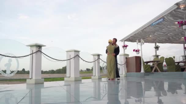 Pareja joven bailando en un restaurante con vistas a la naturaleza . — Vídeos de Stock