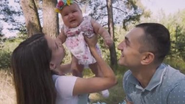 Ağlayan bir bebeği olan bir aile.