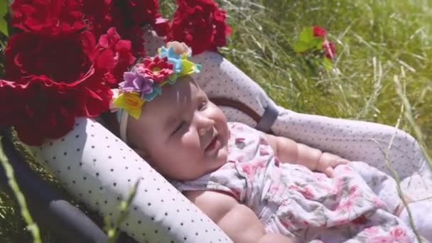 L'enfant est allongé dans l'herbe dans un siège d'auto. — Video