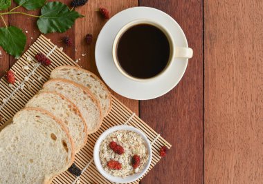 Kahve, ekmek ve ahşap bir masada yulaf ezmesi için kahvaltı. 