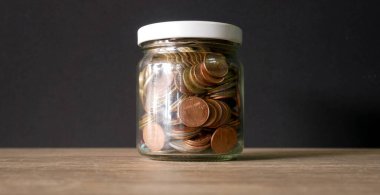 Cam kavanozdaki bozuk para izole edilmiş beyaz arkaplan