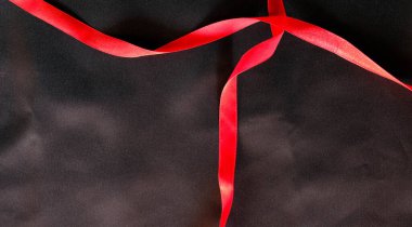 Siyah ipek pamuk arkaplanda kırmızı kurdele