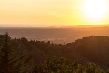 Tuscany sisli panorama, günbatımı üzerinde inişli çıkışlı tepeler ve yeşil alanlar. İtalya, Europe