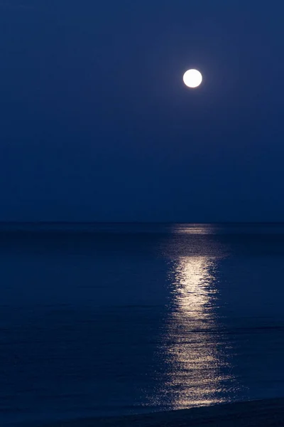 pieno Luna con un' lunare sentiero riflessa nel il specchio di il mare.  12658777 Stock Photo su Vecteezy