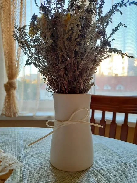 Vase with dried flowers on the table.