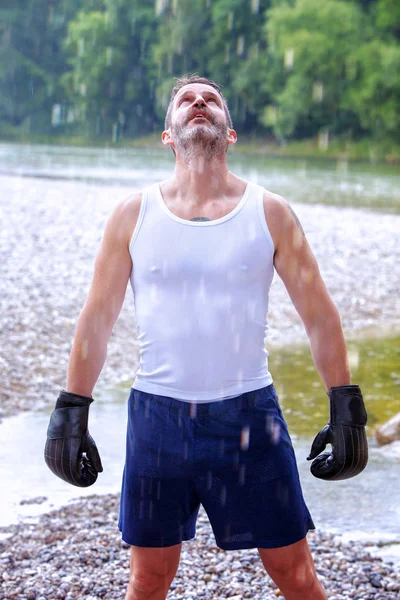 Açık havada yağmur altında duran yakışıklı boksör portresi