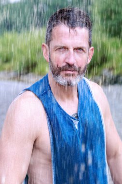 yakışıklı sakallı atlet açık havada yağmur altında duran portresi