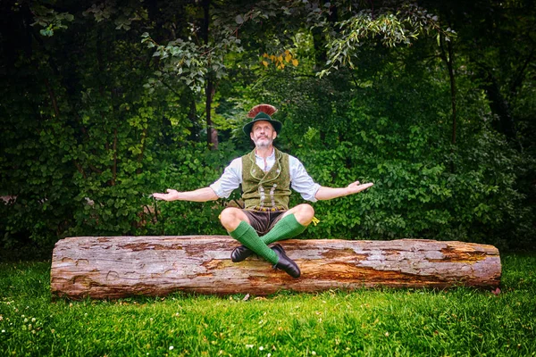 Bayerischer Mann Sitzt Draußen Auf Baumstumpf Und Meditiert — Stockfoto