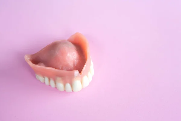Pembe Bir Arka Plan Üzerinde Diş Protez Closeup — Stok fotoğraf