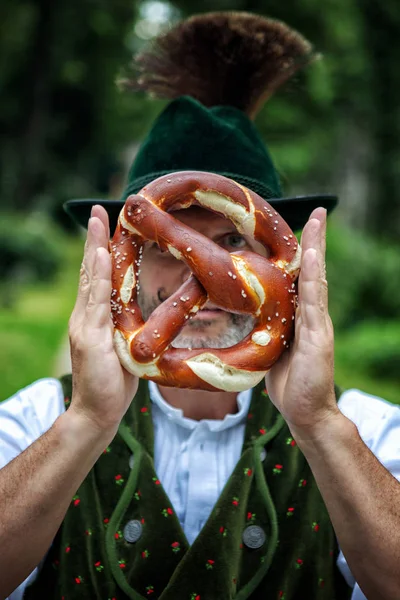 Bavarian Man Holding Pretzel Front His Face Outdoors — Stock Photo, Image
