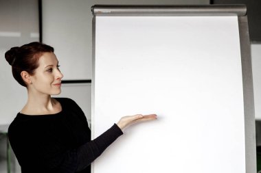 Genç esmer kadın ofiste flipchart işaret