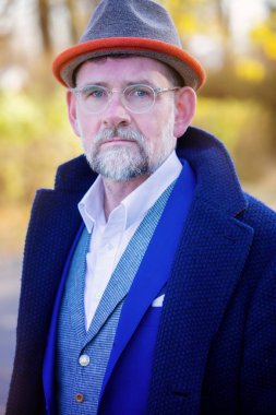 Mavi takım elbise ve ceket açık havada 50'li yakışıklı adam portresi