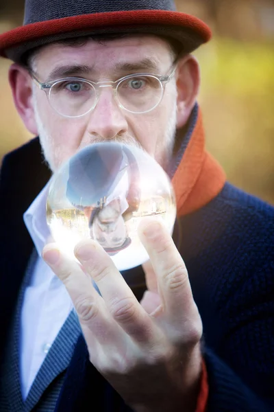 ガラス球を見てハンサムな成熟したビジネスマン — ストック写真
