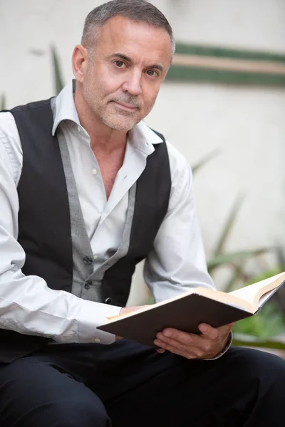 Hombre de negocios guapo sentado fuera y leyendo un libro — Foto de Stock