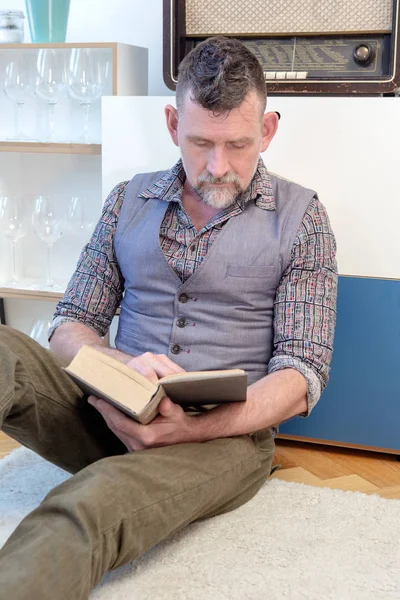 Homem bonito em seus 50 anos lendo um livro — Fotografia de Stock