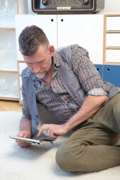 Homem bonito em seus 50 anos olhando para tablet — Fotografia de Stock