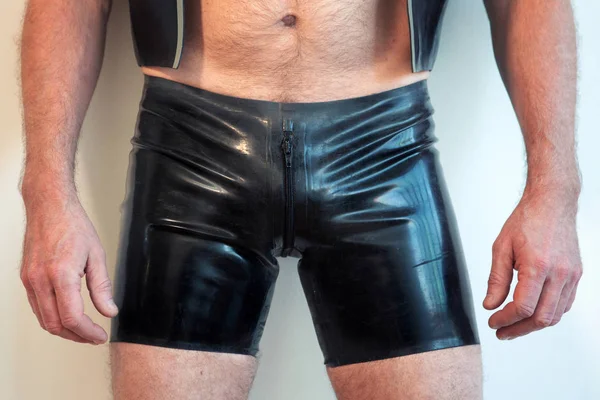 Man draagt korte zwarte latex broek — Stockfoto
