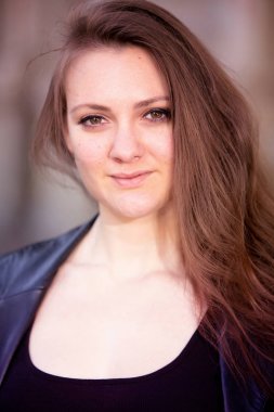 Siyah deri ceket giyen esmer bir kadın.