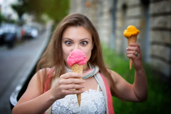 Mujer joven al aire libre sosteniendo dos conos de helado — Foto de Stock