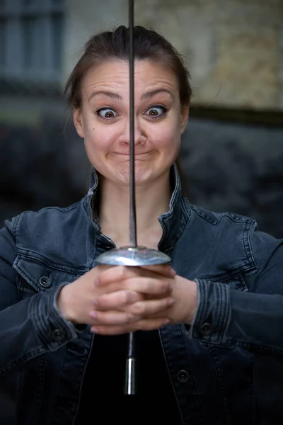 Mladá brunetka se zkříženýma očima žena venku s epee — Stock fotografie