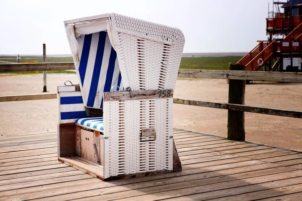 Плетене пляжне крісло на дерев'яній палубі на пляжі — стокове фото