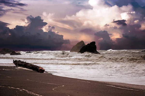 Strand och klippor och vilda vågor på en molnig dag — Stockfoto