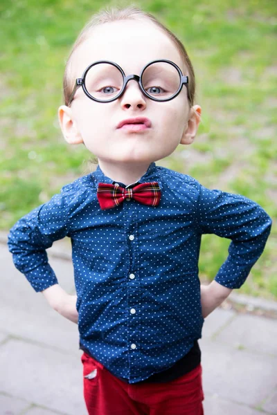Mały chłopiec z wielką głową i okulary patrząc arogancki — Zdjęcie stockowe