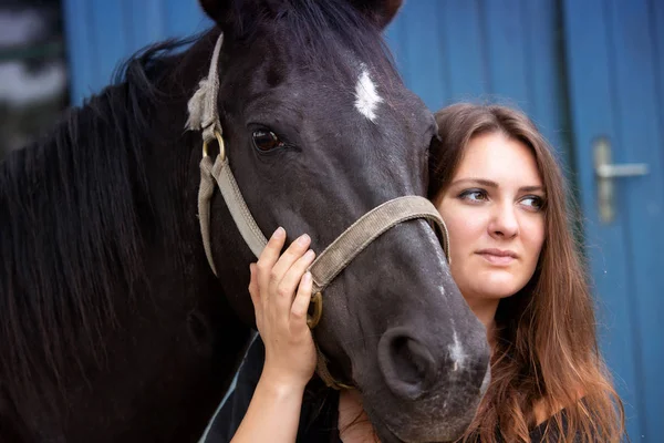 Portrait of young woman with her black horse — Stock Photo, Image