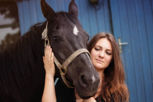 Portrait of young woman with her black horse — Stock Photo, Image