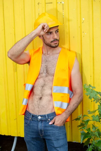 Sarı inşaat kask ile seksi gömleksiz işçi — Stok fotoğraf