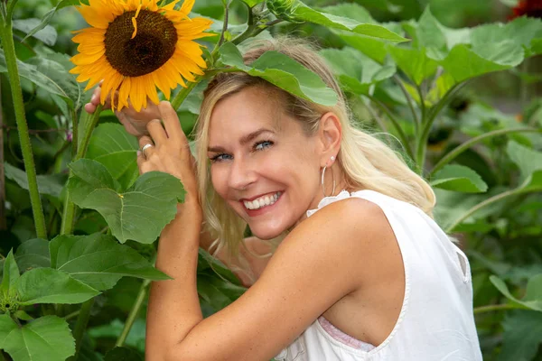 Retrato de mulher loira no jardim com girassóis — Fotografia de Stock