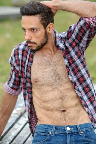 Retrato de hombre sexy con camisa abierta sentado al aire libre — Foto de Stock