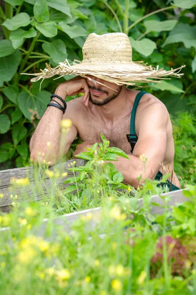 정원에서 짚 모자를 풀고 있는 수염을 기른 사람의 모습 — 스톡 사진