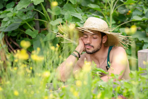 Retrato de homem barbudo com chapéu de palha relaxante no jardim — Fotografia de Stock