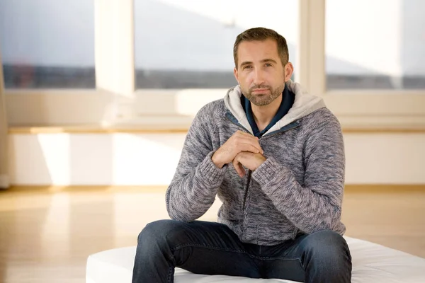 Handsome bearded man sitting indoor wearing a cardigan — Stock Photo, Image