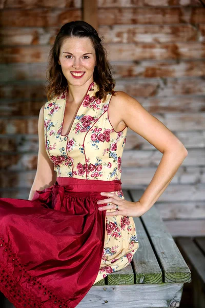 Bavaroise femme dans dirndl assis dans une cabane — Photo