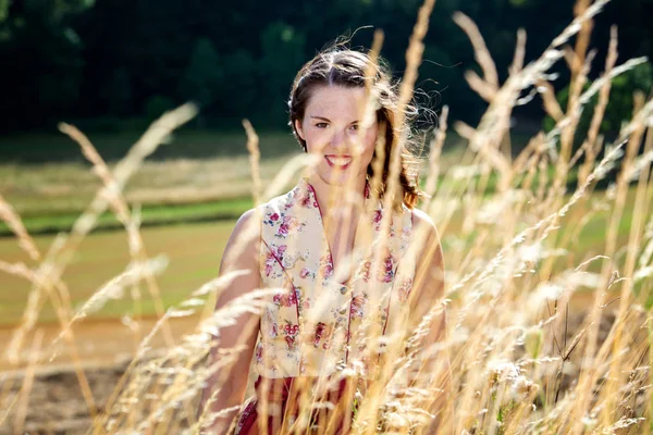 Mladá žena v dirndl, stojící v kukuřičním poli — Stock fotografie