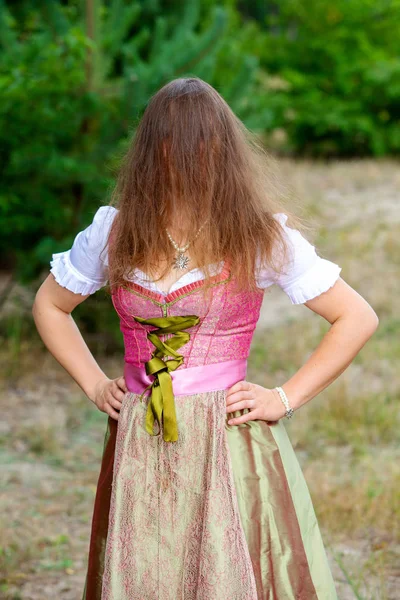 Junge Frau im Dirndl versteckt ihr Gesicht hinter ihren Haaren — Stockfoto