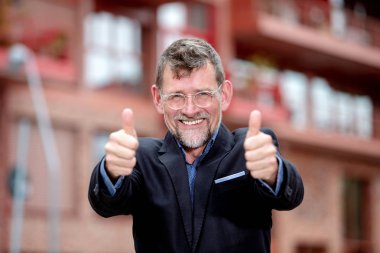 yakışıklı işadamı kadar iki başparmak gösteren