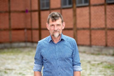 dışında duran mavi gömlek li 50'li yakışıklı adam