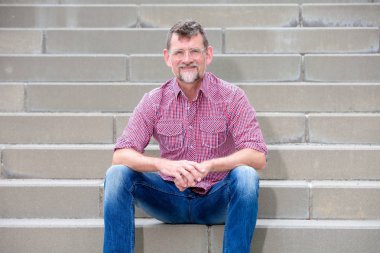 50'li yıllarda yakışıklı adam merdivenlerde oturan ve gülümseyen