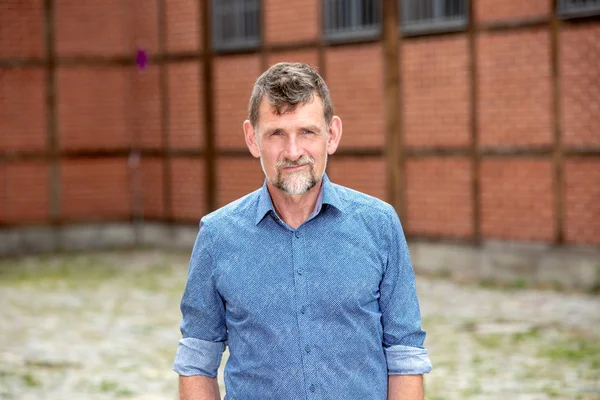 dışında duran mavi gömlek li 50'li yakışıklı adam