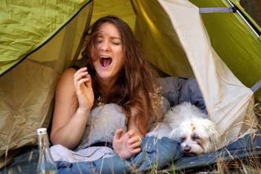 genç kadın onu beyaz köpek ve esneme ile çadırda yalan