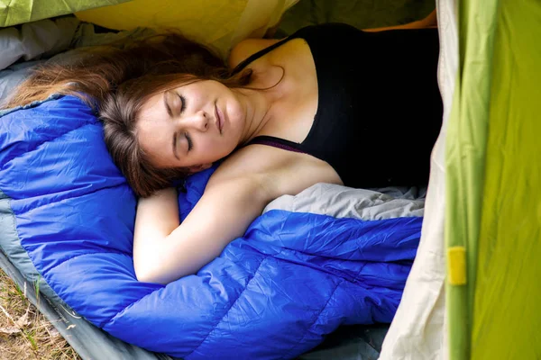 Giovane donna bruna sdraiata in tenda e dormire — Foto Stock