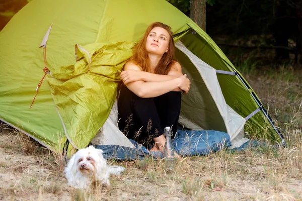 genç kadın köpeği ile çadırının önünde oturan