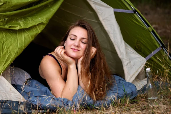 Giovane donna bruna sdraiata in tenda con gli occhi chiusi — Foto Stock