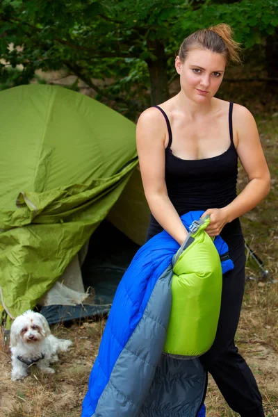 Junge Frau vor dem Zelt beim Einpacken ihres Schlafsacks — Stockfoto