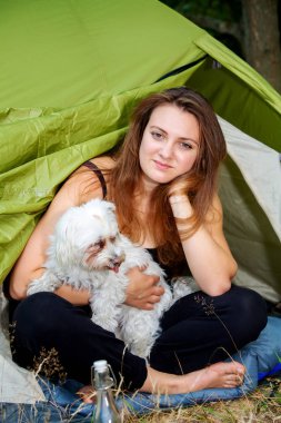 genç kadın köpeği ile çadırının önünde oturan