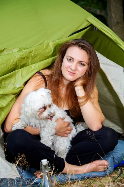 genç kadın köpeği ile çadırının önünde oturan